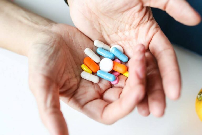 Pile of pills in persons hands